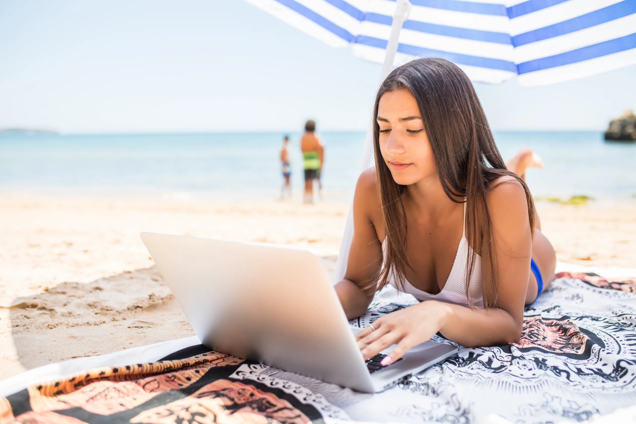 studentessa lavora alla tesi al pc in spiaggia